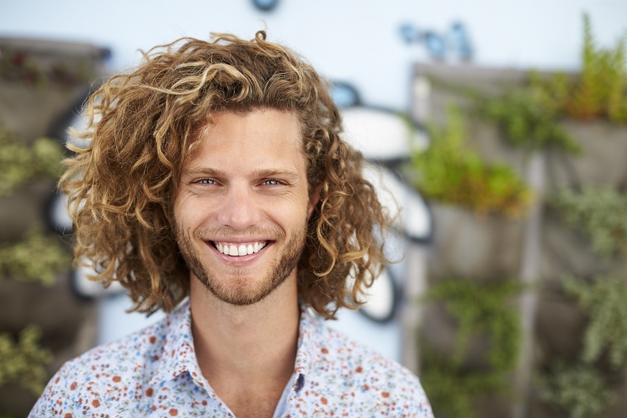 guy with long curly hair and highlights