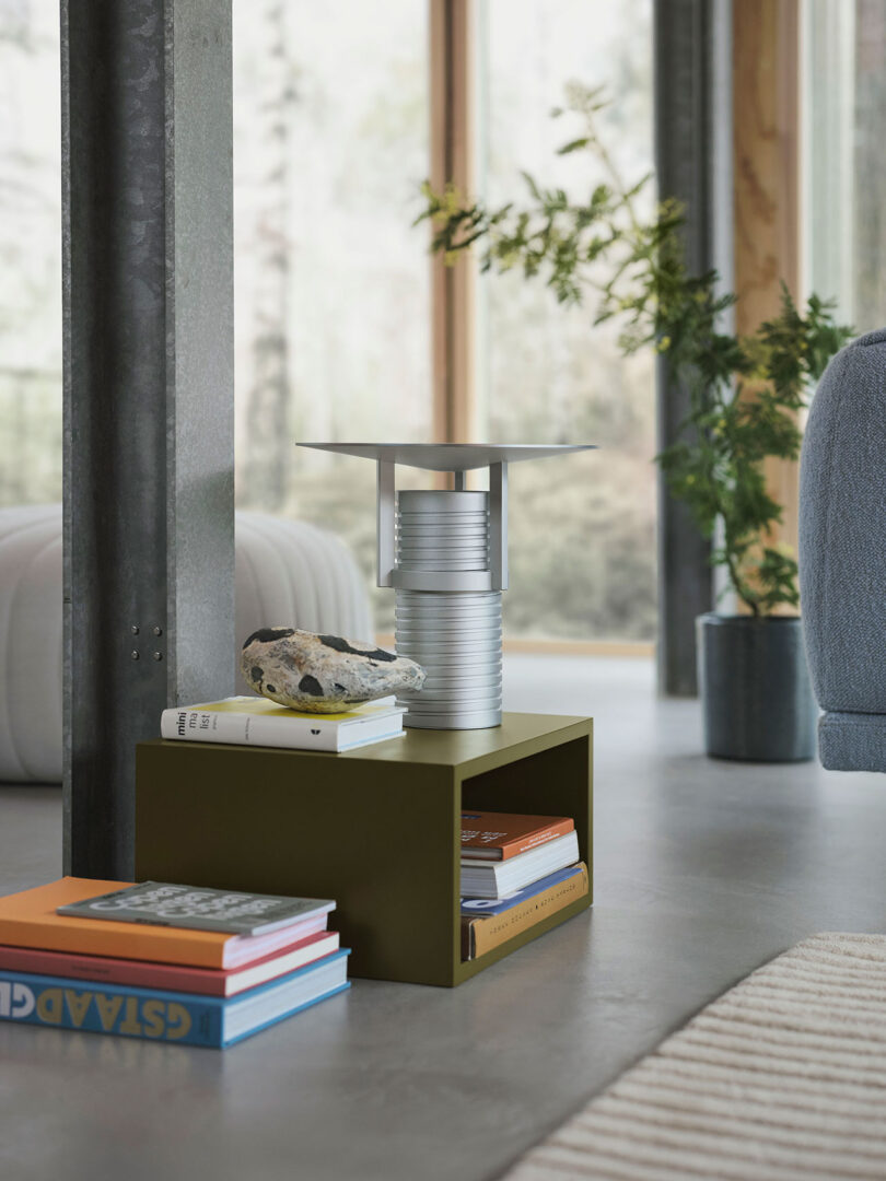 Modern adjustable metal table lamp with a cylindrical base, showcased on a styled side table.