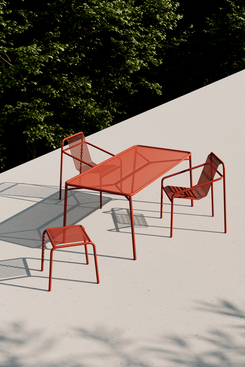 Modern red outdoor furniture casting shadows in sunlight.